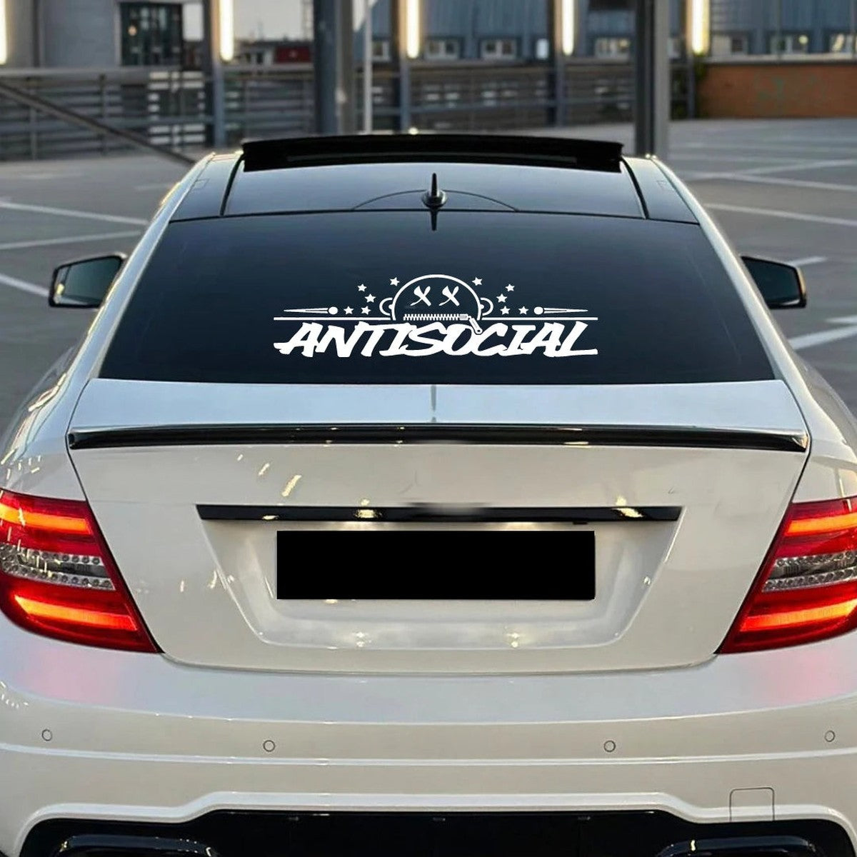 White Antisocial rear window banner decal on a white Mercedes coupe