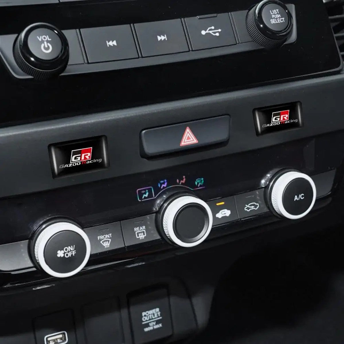 Two GR-style epoxy badges on a Toyota dashboard console
