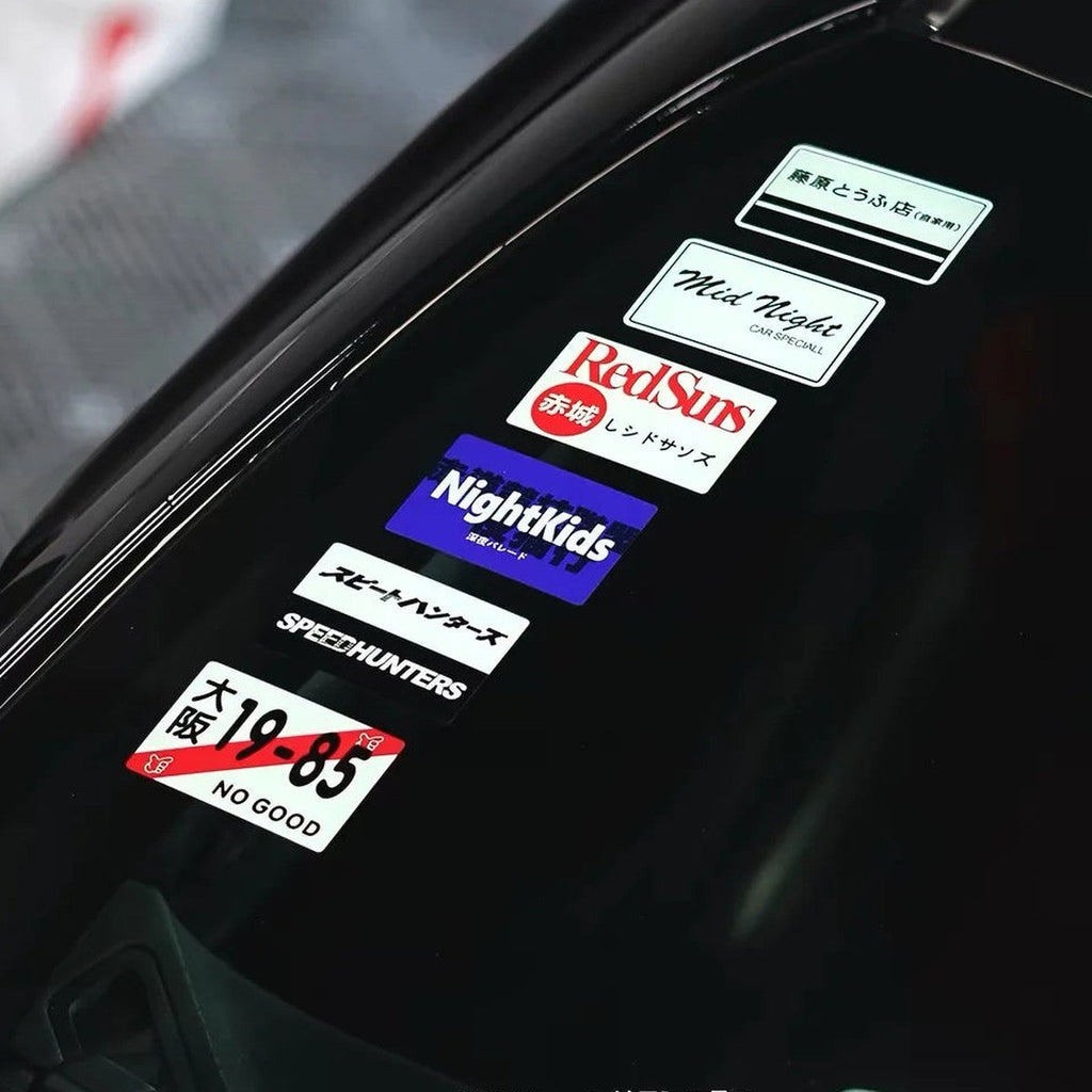 JDM static cling decals stacked on the inside of a car windshield