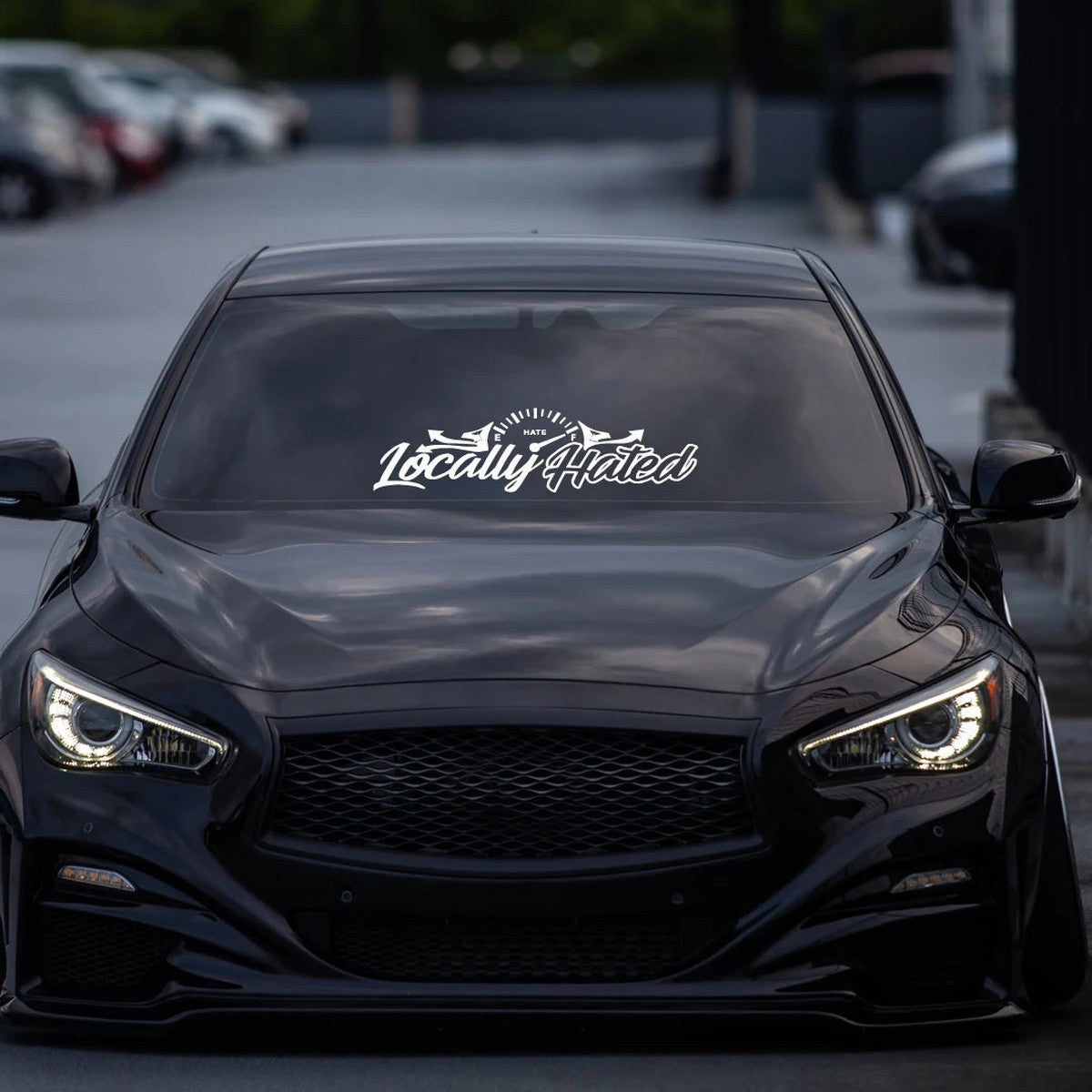 Locally Hated windshield banner on a black Infiniti sedan