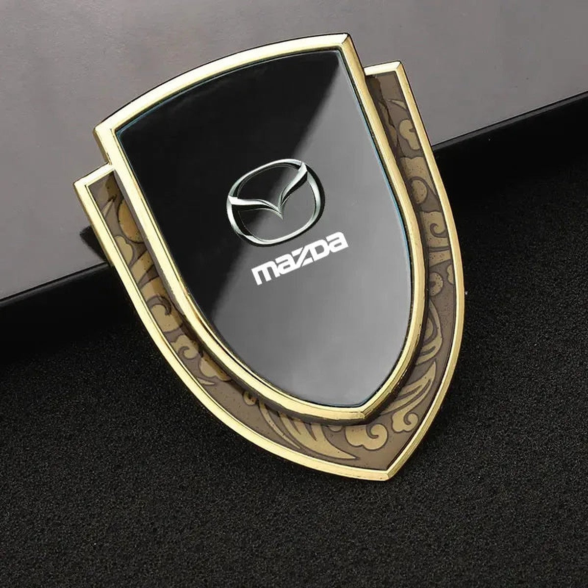 Gold-frame black Mazda-style shield emblem, style B-1
