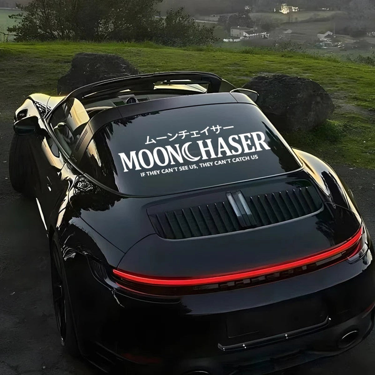 Moonchaser banner decal on the rear window of a black Porsche