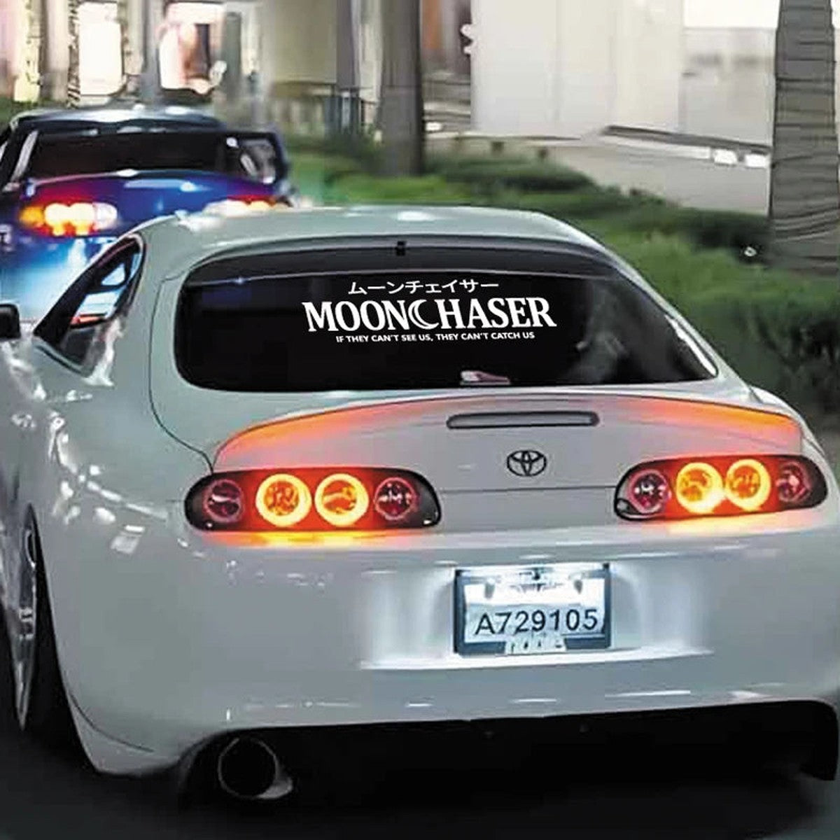 White Moonchaser banner on the rear window of a white Toyota Supra