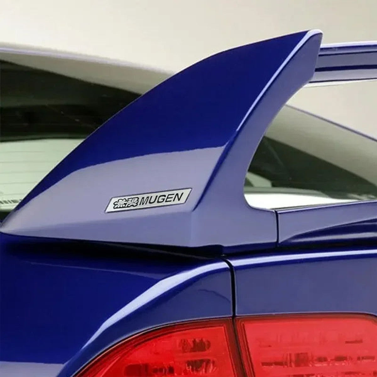 Mugen-style aluminum badge on a blue Civic rear spoiler