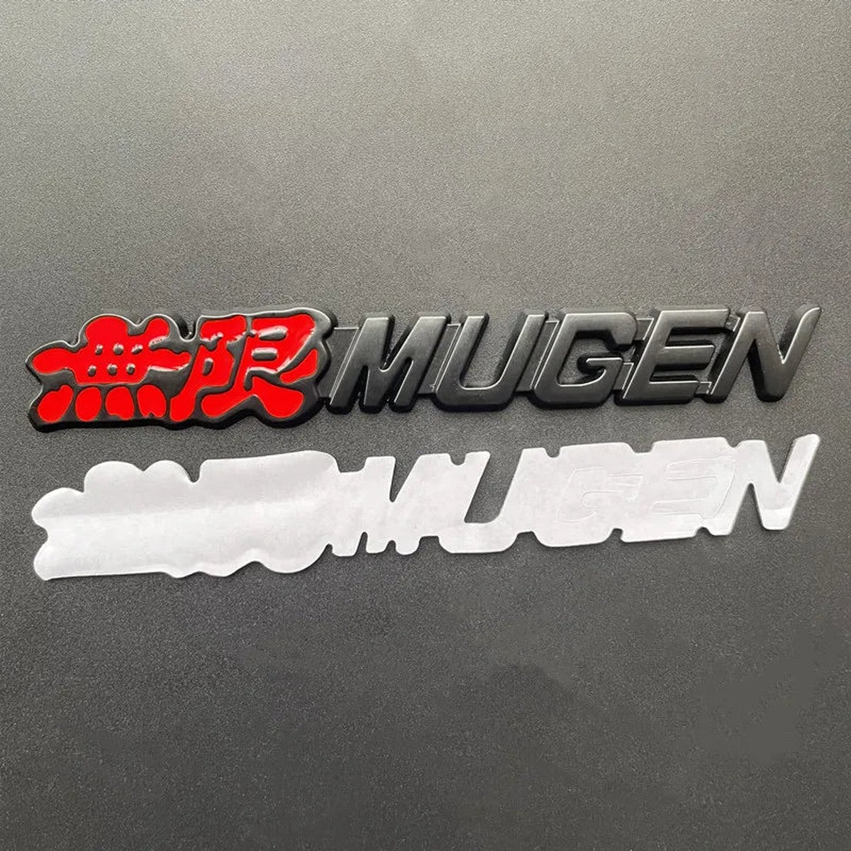 Black Mugen-style metal emblem with adhesive backing