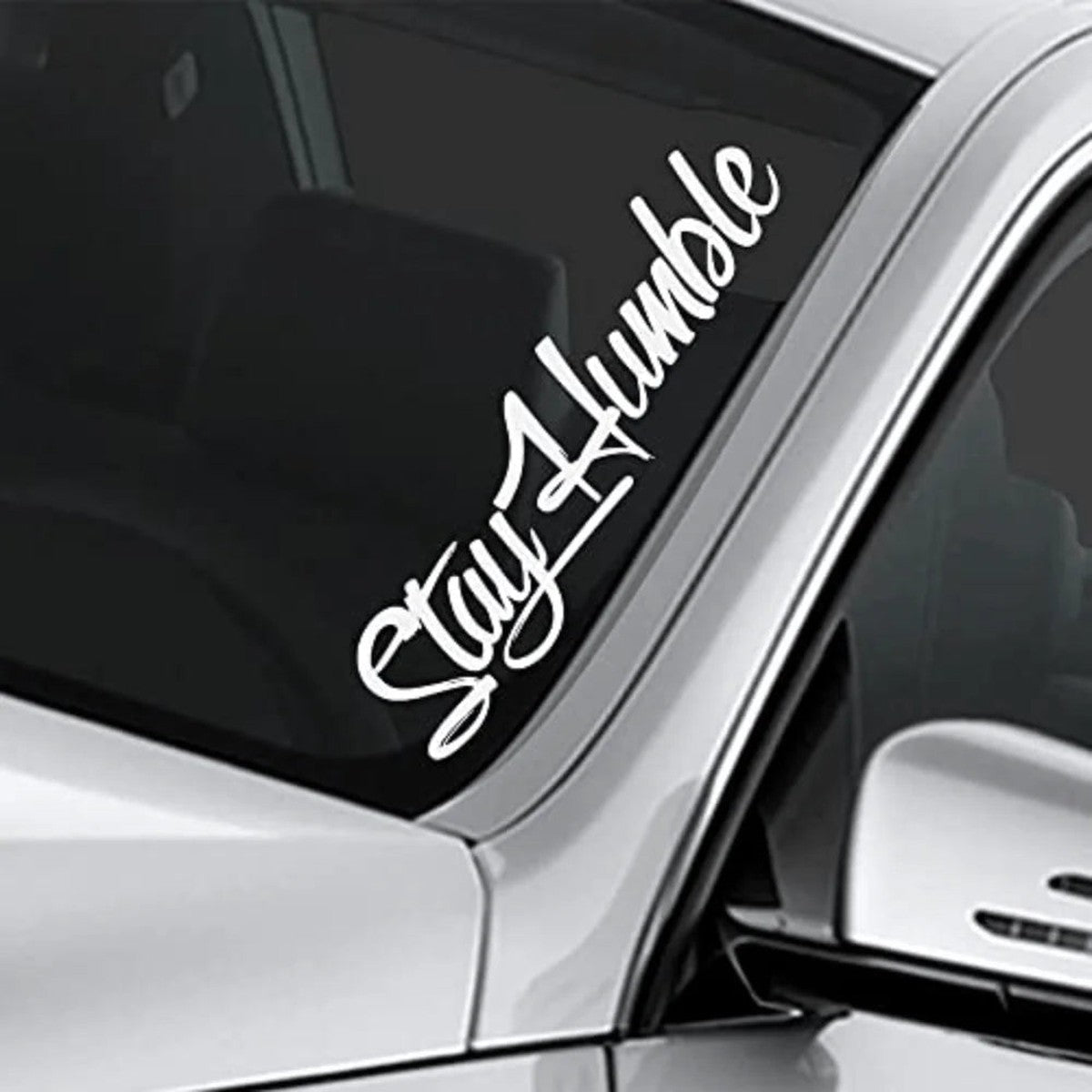 Stay Humble windshield decal on a white car, close-up