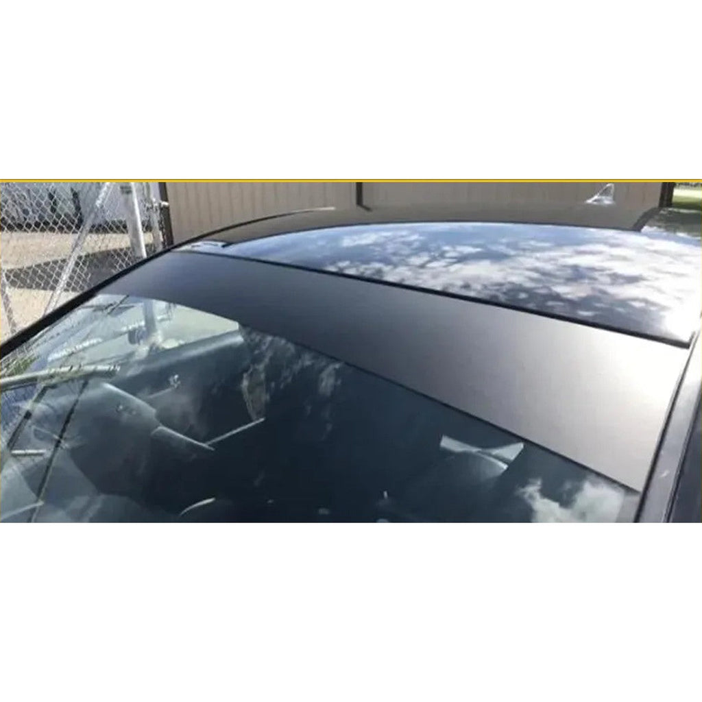 Close-up of a matte black windshield sun visor strip on a hatchback