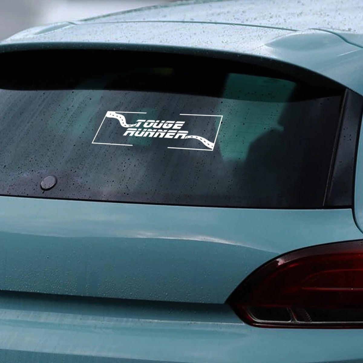 White Touge Runner sticker on a teal hatchback rear window