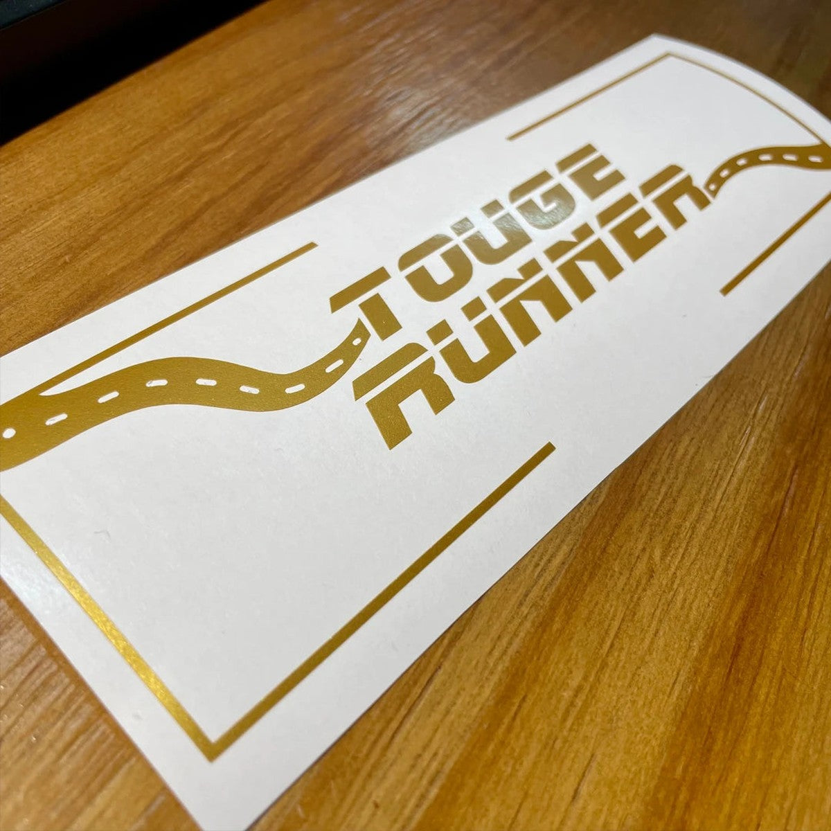 Gold Touge Runner vinyl sticker on its transfer tape