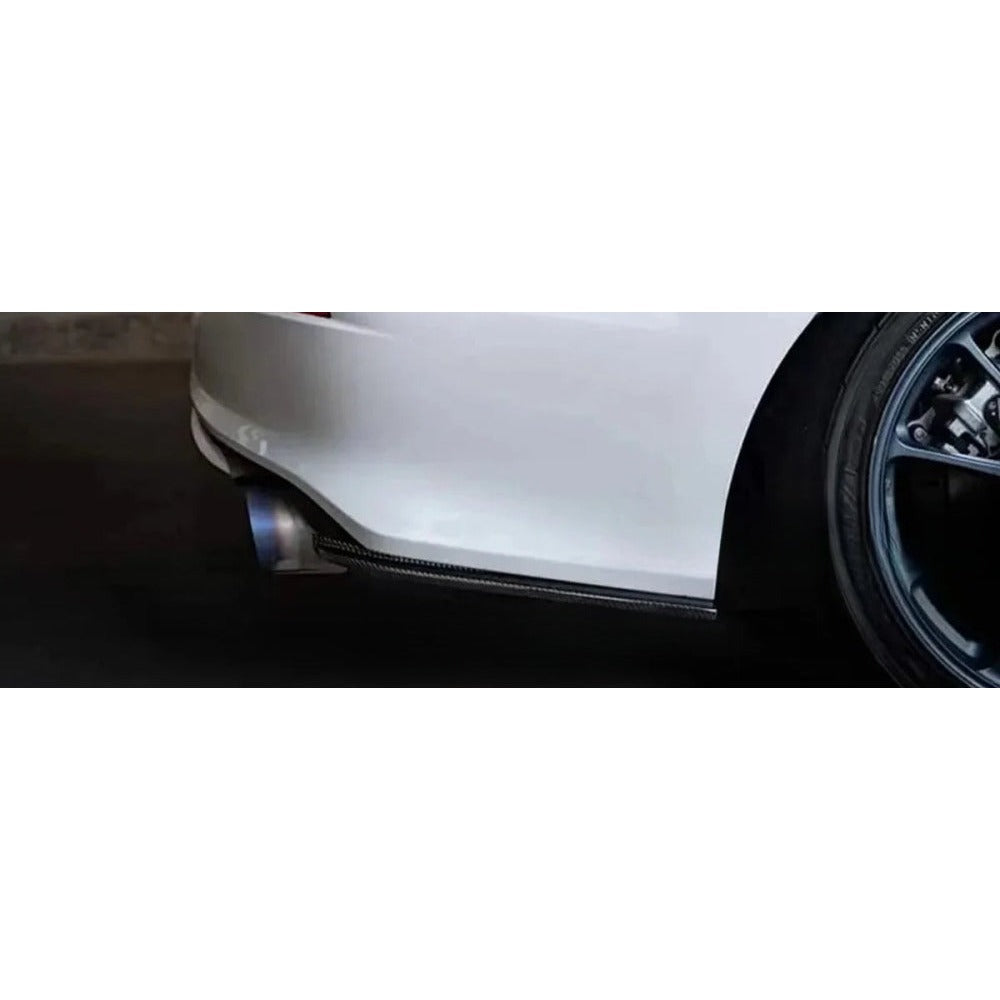 Rear bumper side splitter installed on a white car, close-up of the lower bumper corner